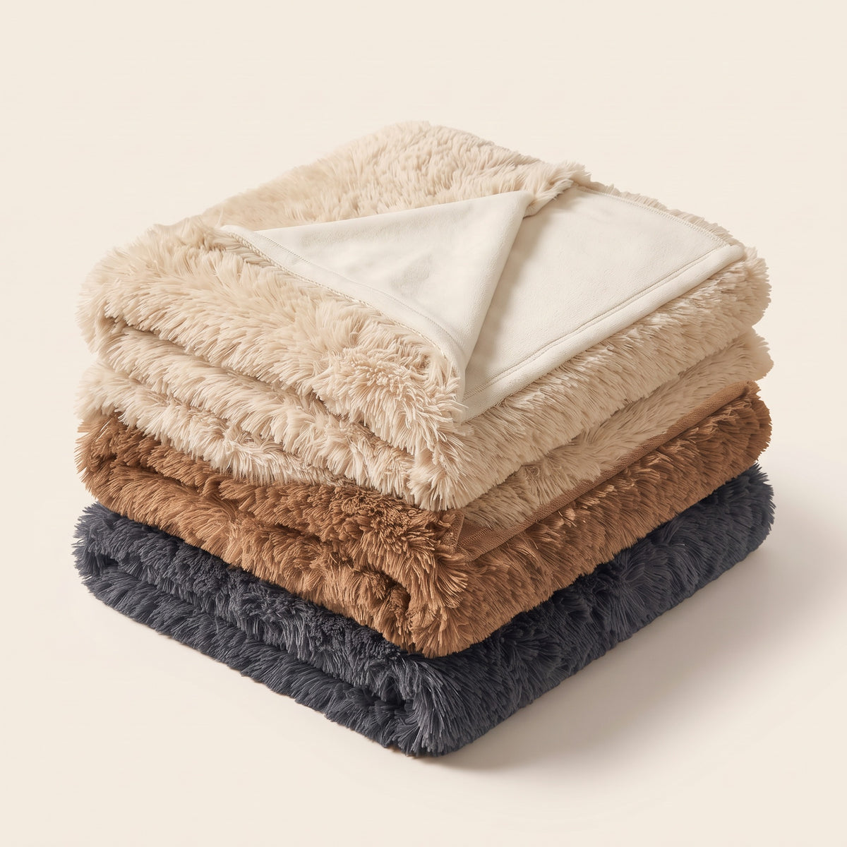 Kuscheldecke gefaltet in allen drei Farben: Beige, Camel und Dunkelgrau